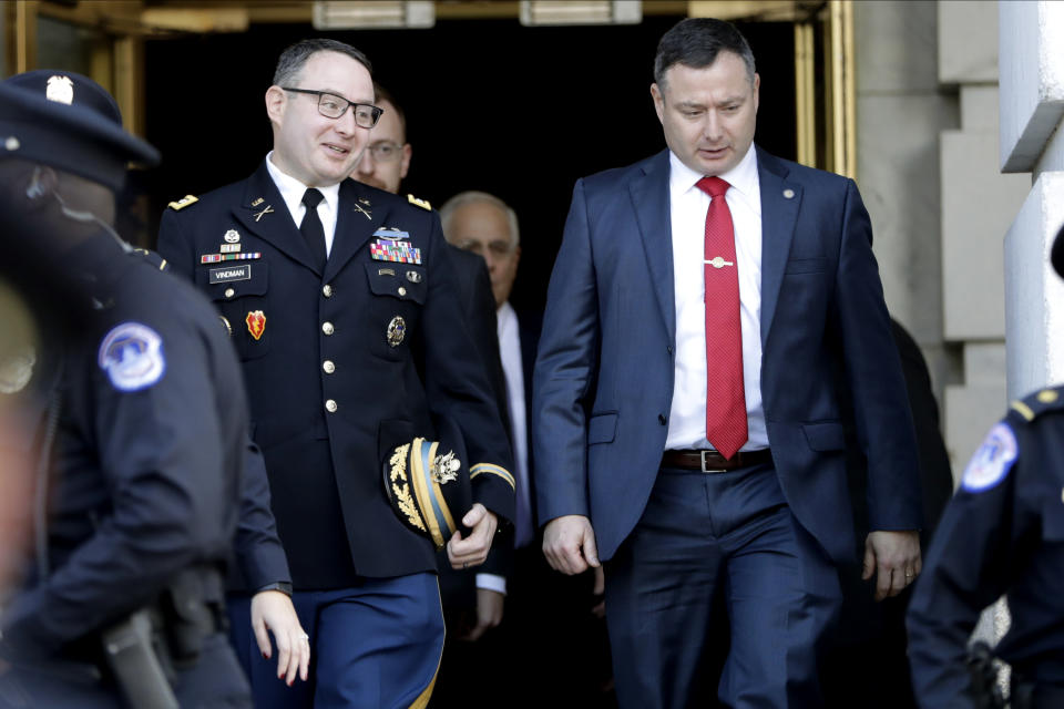 FILE - In this Nov. 19, 2019, file photo then National Security Council aide Lt. Col. Alexander Vindman, left, walks with his twin brother, Army Lt. Col. Yevgeny Vindman, after testifying before the House Intelligence Committee on Capitol Hill in Washington, during a public impeachment hearing of President Donald Trump's efforts to tie U.S. aid for Ukraine to investigations of his political opponents. The Army confirms that both Lt. Cols. Vindman have been reassigned to the Department of the Army,(AP Photo/Julio Cortez, File)