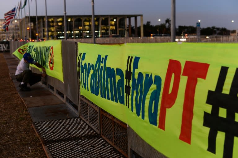 A man places banner in favour of suspended president Dilma Rousseff's impeachment outside the Brazilian national Congress in Brasilia on August 26, 2016