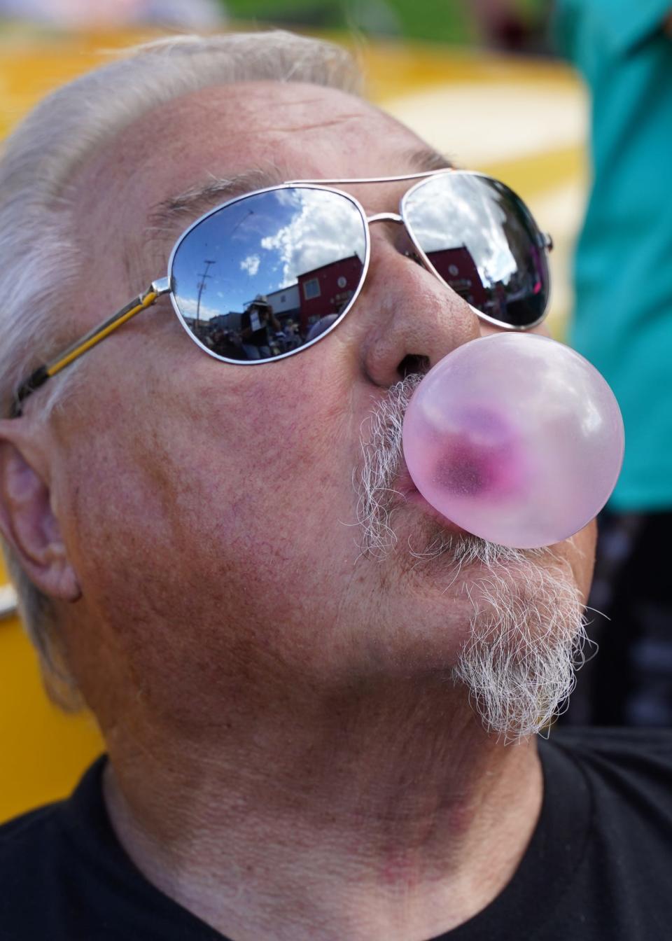 Ron Wilson of Adrian blows a bubblegum bubble Tuesday, Aug. 9, 2022, in downtown Adrian during the 20th anniversary celebration at Nova's Soda Pop Candy Shop, 105 E. Church St. The theme of the anniversary event was 1950s-60s and also featured a hula hoop contest.
