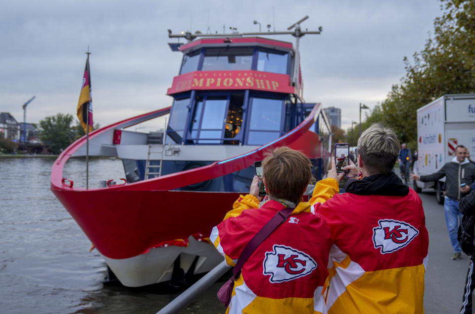 Two women from Kansas City take pictures of a ship that docked in Frankfurt, Germany, Wednesday, Nov. 1, 2023. The Miami Dolphins are set to play the Kansas City Chiefs in an NFL game in Frankfurt on Sunday Nov. 5. The ship was chartered by the chiefs. (AP Photo/Michael Probst)