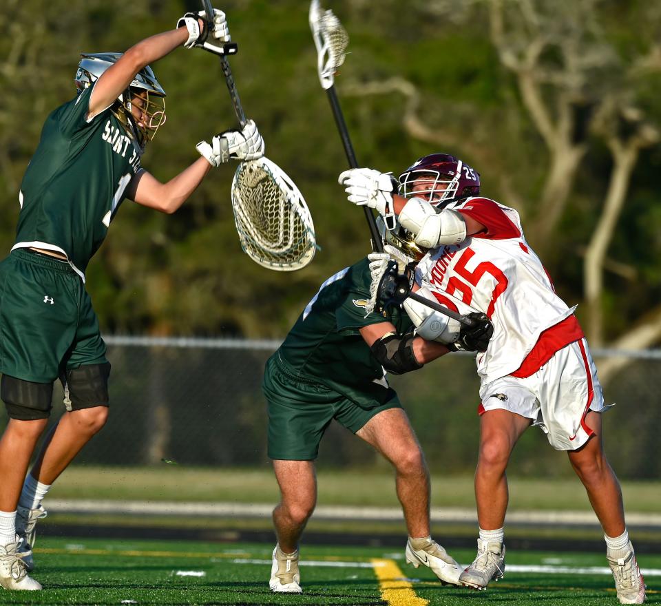 Cardinal Mooney's (25) Carston Shepherd scores the second point of the game against Saint Stephen's goaltender Nick Pagnotta (1) during the Class 1A-Region 3 quarterfinal at John Heath Field at Austin Smithers Stadium in Sarasota on Wednesday night, April, 20, 2022.