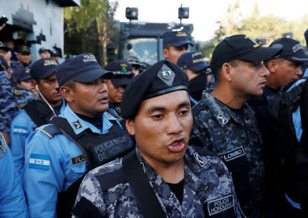 Police officers sing the national anthem outside the headquarters of Honduras' elite police force, after an agreement with the government not to crack down on demonstrators in the marches over a contested presidential election, according to local media, in Tegucigalpa, Honduras December 5, 2017. REUTERS/Henry Romero