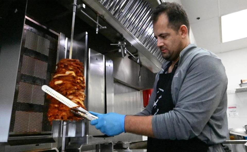Chef Khalid Wasiq carefully cuts chicken shawarma for a rice platter at Halal Bros Monday, 2023 in Fresno.