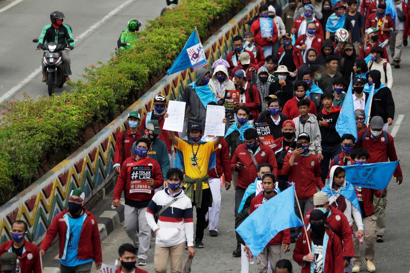 Indonesian labor unions march on a main road towards the Presidential Palace during a strike to protest against the government's proposed labour reforms in a controversial "jobs creation" bill in Jakarta