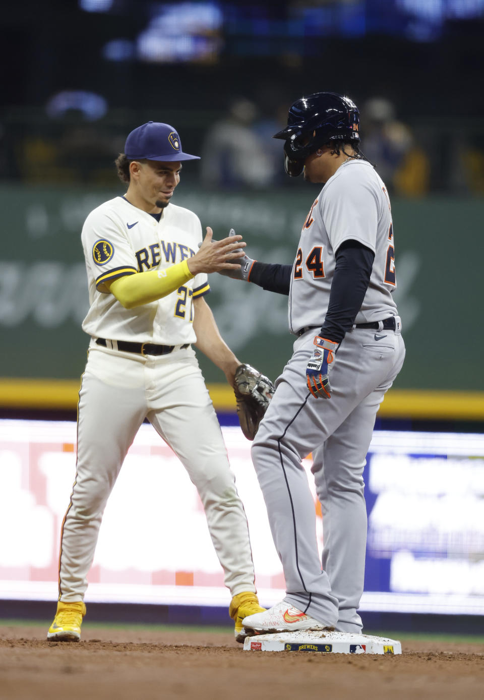 Milwaukee Brewers' Willy Adames (27) and Detroit Tigers' Miguel Cabrera greet one another during the third inning of a baseball game Tuesday, April 25, 2023, in Milwaukee. (AP Photo/Jeffrey Phelps)