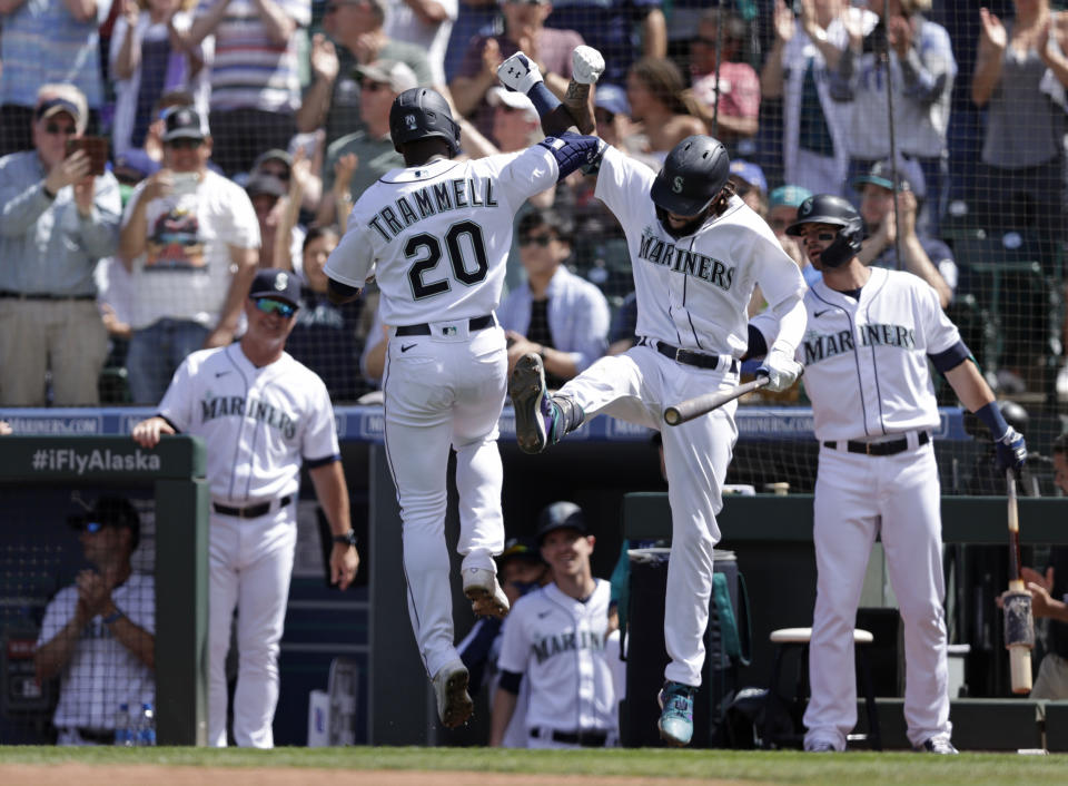 Seattle Mariners' Taylor Trammell is greeted at home by J.P. Crawford after hitting a solo home run on a pitch from Colorado Rockies starting pitcher German Marquez during the sixth inning a baseball game, Wednesday, June 23, 2021, in Seattle. (AP Photo/John Froschauer)