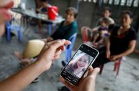 A relative looks at an image of Anna Bui Thi Nhung, a victim who was found dead in the back of British truck, at her home in Nghe An province