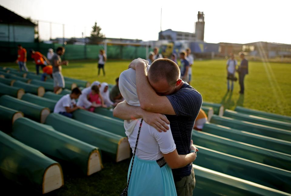 Bosnian Muslims cry near the coffins of relatives before a mass funeral for bodies found in a mass grave, in Kozarac, near Prijedor, July 19, 2014. (REUTERS/Dado Ruvic)