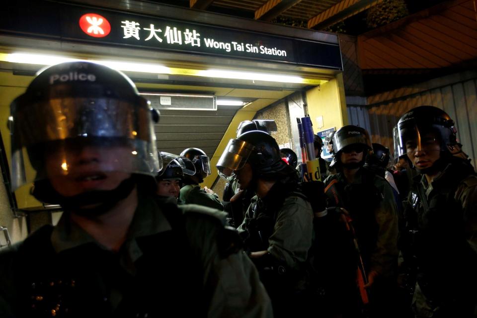 Riot police stand next Wong Tai Sin station entrance during a protest in Hong Kong (REUTERS)