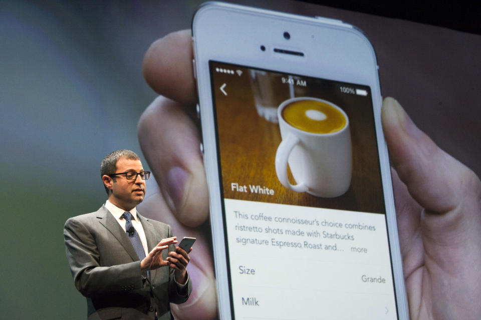 Starbucks Chief Digital Officer Adam Brotman demonstrates how to order a drink using the mobile ordering system during the company's annual shareholder's meeting in Seattle, Washington March 18, 2015. Starbucks Corp will begin offering delivery in New York City and Seattle later this year, when it also plans to expand mobile order and pay services across the United States.  REUTERS/David Ryder  (UNITED STATES - Tags: BUSINESS)