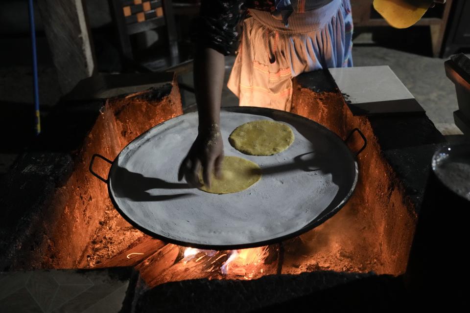 A young woman cooks tortillas over a fire in her kitchen in Plan de Ayala, a Tojolabal village in the Las Margaritas municipality of Chiapas state, Mexico, Thursday, May 2, 2024. Two women are on Mexico’s ballot for president while women in some Indigenous areas have no voice in their own villages. However, with help from younger generations, some Indigenous women are pushing for change. (AP Photo/Marco Ugarte)