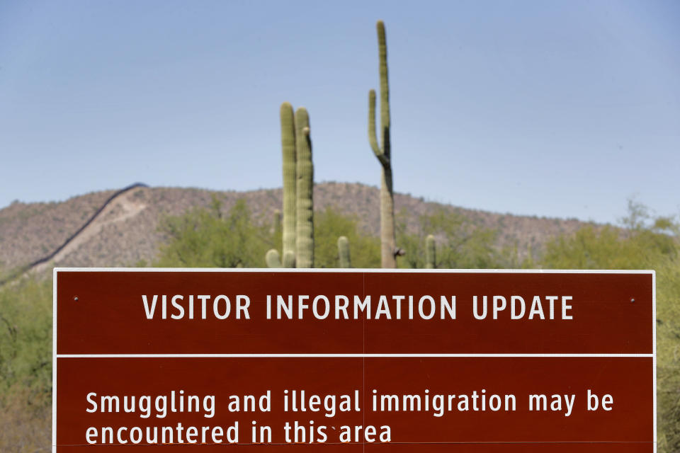 An uphill section of the international border wall that runs through Organ Pipe National Monument is shown above a park warning sign, Thursday, Aug. 22, 2019 in Lukeville, Ariz. Construction on a two mile portion of replacement fencing funded by President Trump's national emergency declaration has begun in an area near the official border crossing that runs through Organ Pipe. (AP Photo/Matt York)