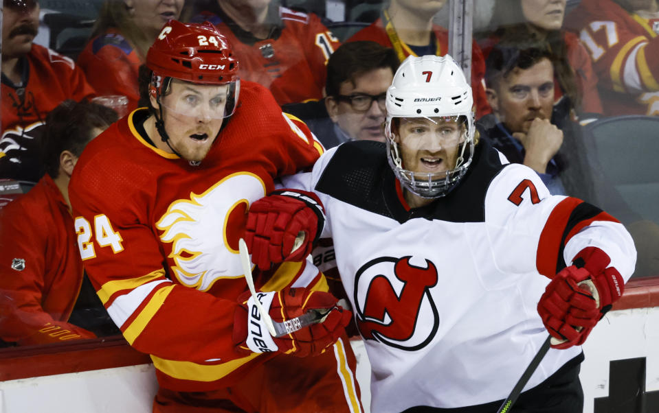 FILE - New Jersey Devils' Dougie Hamilton, right, checks Calgary Flames' Brett Ritchie during the first period of an NHL hockey game, Wednesday, March 16, 2022, in Calgary, Alberta. Coming into the 2022-2023 season, the Devils have missed the playoffs the last four years. (Jeff McIntosh/The Canadian Press via AP, File)