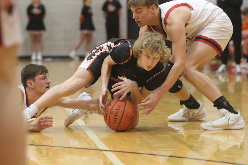 Lucas' Bobby Grover battles Crestview's Karter Goon (right) and Jarek Ringler (left) for a loose ball during the Cougars' 72-61 win over the Cubs on Monday night.
