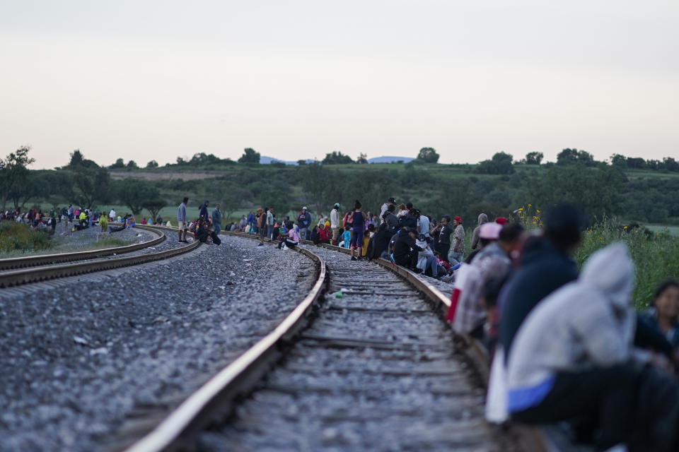 Migrants wait along rail lines hoping to board a freight train heading north, one that stops long enough so they can hop on, in Huehuetoca, Mexico, Sept. 19, 2023. Ferromex, Mexico's largest railroad company announced that it was suspending operations of its cargo trains due to the massive number of migrants that are illegally hitching a ride on its trains moving north towards the U.S. border. (AP Photo/Eduardo Verdugo)