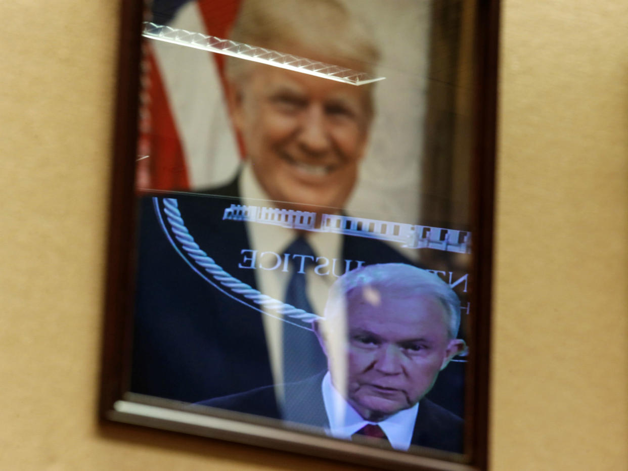 Video image Jeff Sessions is reflected in a picture of Donald Trump: REUTERS/Joshua Roberts