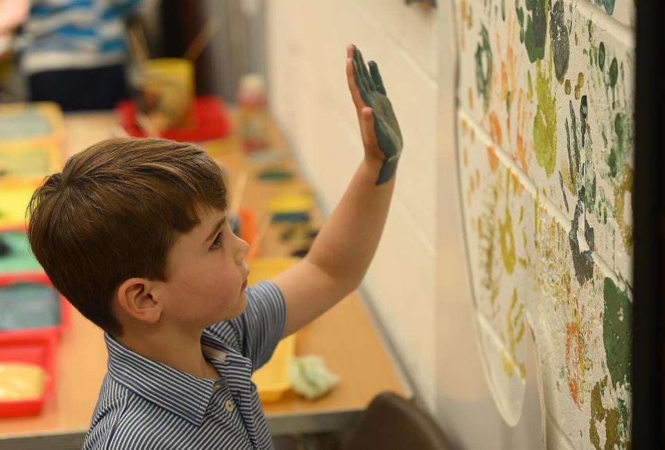 Prince Louis leaves his handprint on a mural at the 3rd Upton Scouts Hut.