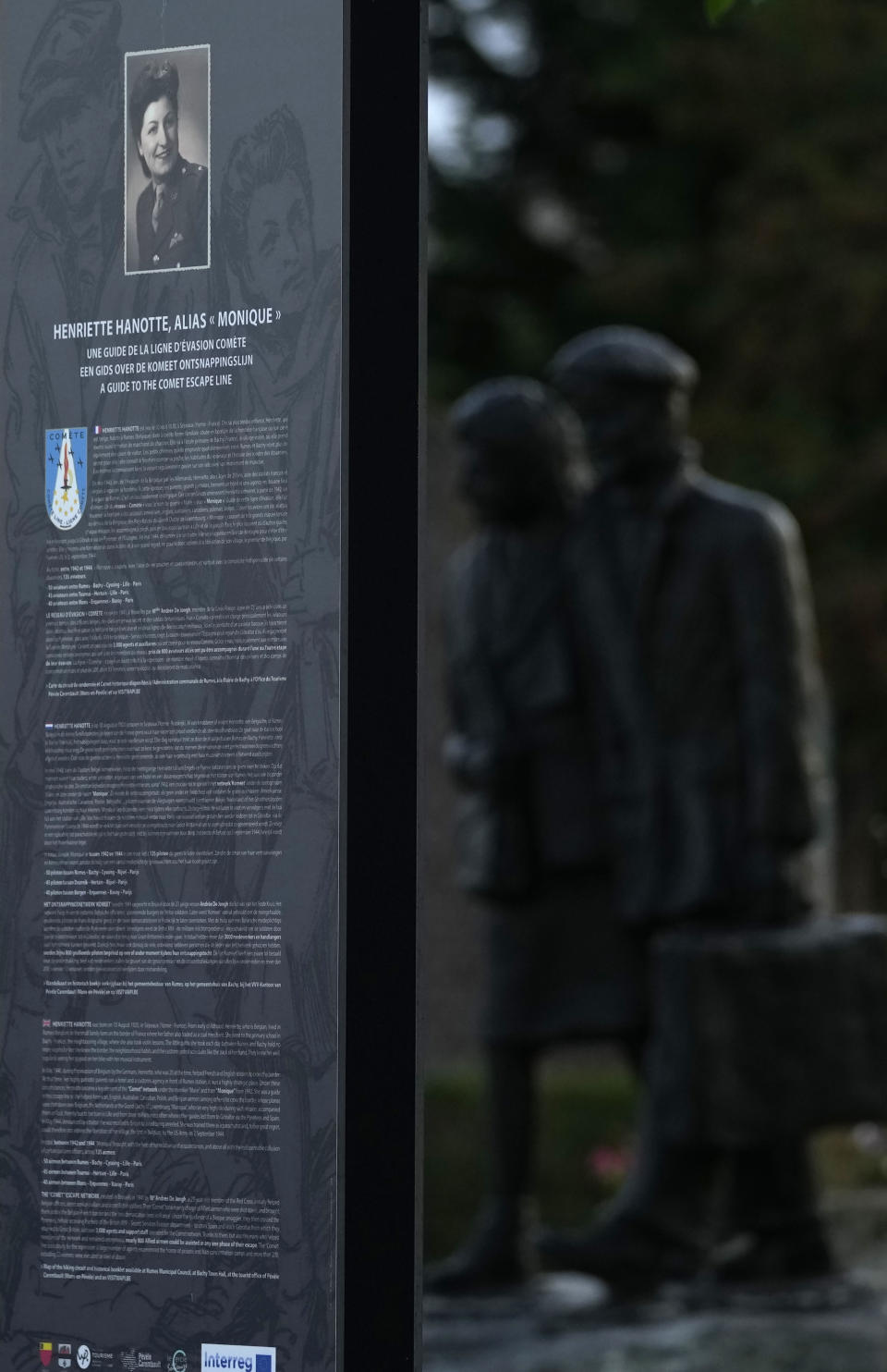 An information board and a statue depicting Henriette Hanotte helping American pilot Charles Carlson stands in the center of the town of Bachy, France, Friday, Sept. 16, 2022. Hanotte was a Belgian resistance member during World War II and from the age of nineteen aided the escape of nearly 140 airmen from occupied Belgium into France as part of the Comet Line. (AP Photo/Virginia Mayo)