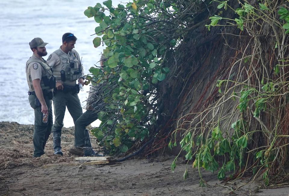 Florida Fish and Wildlife Conservation Commission employees guard the area where ancient human remains were uncovered onNovember 11, 2022 by Hurricane Nicole on Chastain Beach.