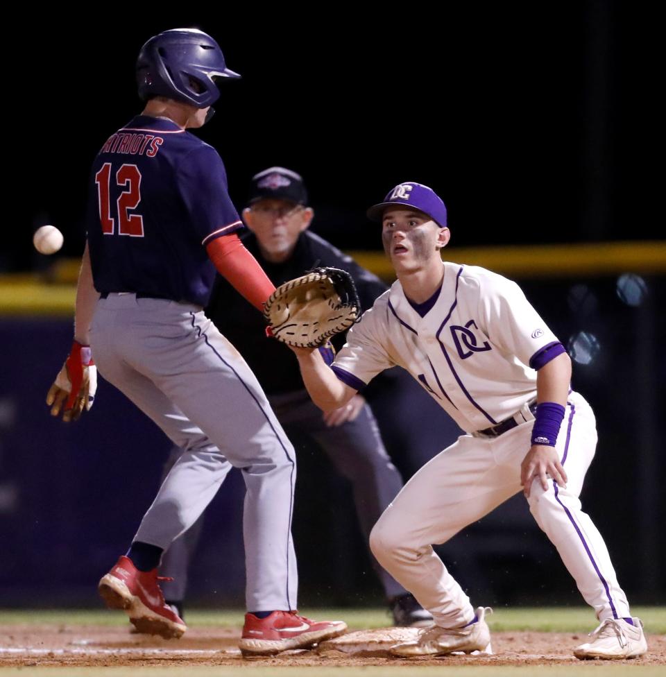 DeSoto Central's Gavin Brassfield (4) awaits the pickoff throw while Lewisburg's Jarrett Morris (12) runs back to first base during a game Thursday, April 14, 2022, at DeSoto Central High School. DeSoto Central defeated Lewisburg, 8-5.