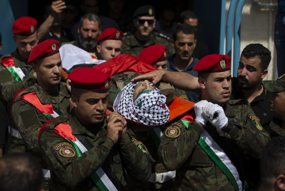 Palestinian security officers carry the body of a their colleague, Tayseer Issa, in the West Bank city of Jenin, Thursday, June 10, 2021. Israeli troops shot and killed three Palestinians, including two security officers, in a shootout that erupted in the West Bank town of Jenin during what appeared to be an Israeli arrest raid overnight, Palestinian officials said Thursday. (AP Photo/Majdi Mohammed)