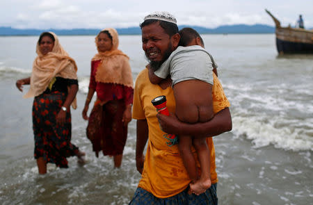 A Rohingya refugee man cries as he walks to the shore after crossing the Bangladesh-Myanmar border by boat through the Bay of Bengal in Shah Porir Dwip, Bangladesh, September 10, 2017. REUTERS/Danish Siddiqui