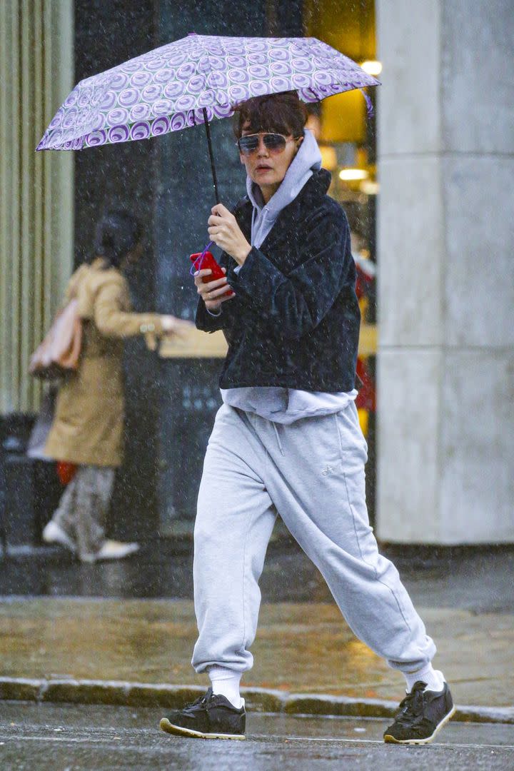 A pesar de su look deportivo, Katie Holmes fue descubierta por las calles lluviosas de Nueva York. Mientras que con una mano sostenía un paraguas, en la otra llevaba su celular buscando una ubicación específica. A pesar del mal tiempo, la actriz usó gafas de sol para camuflarse entre la multitud, aunque no tuvo éxito