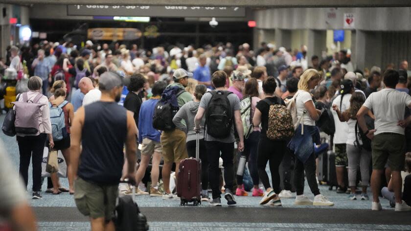 People gather while waiting for flights at the Kahului Airport Wednesday, Aug. 9, 2023, in Kahului, Hawaii. Several thousand Hawaii residents raced to escape homes on Maui as the Lahaina fire swept across the island, killing multiple people and burning parts of a centuries-old town. (AP Photo/Rick Bowmer)