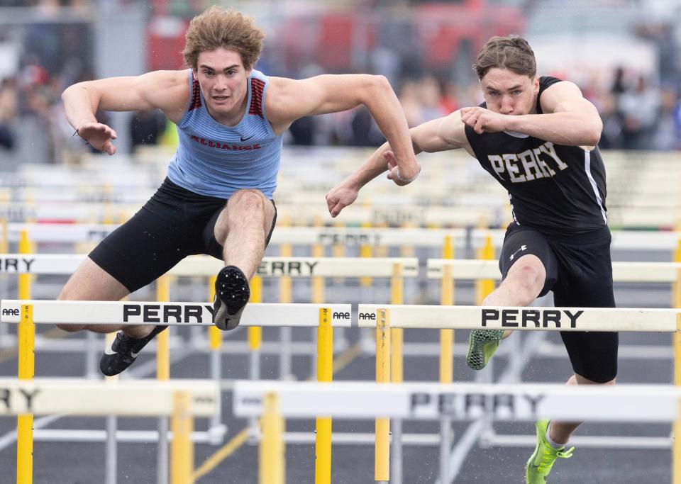 Alliance's Brendan Zurbrugg, left, edges Garrett Laubacher of Perry in the 110-meter hurdles at the Stark County Championships, Saturday, April 22, 2023, at Perry High School.