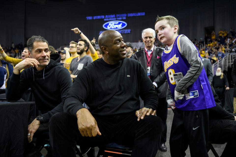 Earvin "Magic" Johnson, former Los Angeles Lakers' player and current president of operations of the team, talks to Sam Schulz while sitting court-side during the Murray State Racers versus Jacksonville State Gamecocks semifinal match up at the Ohio Valley Conference tournament held at Ford Center in Evansville, Ind., Friday, March 8, 2019.