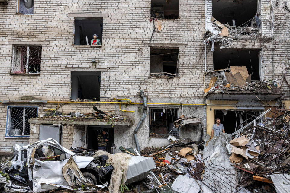 People stand on debris of a residential building destroyed by a strike, amid Russia's invasion of Ukraine, in Mykolaiv, Ukraine, September 11, 2022. REUTERS/Umit Bektas