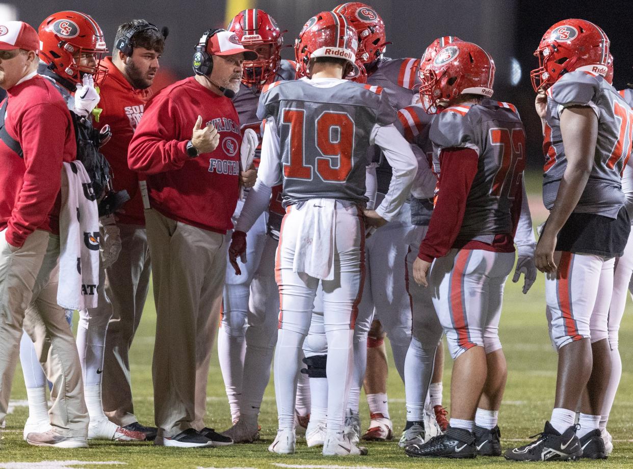 Canton South football players huddle around head coach Matt Dennison during a home playoff game against Buchtel, Friday, Nov. 3, 2023.