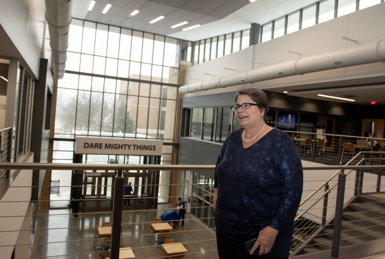 Christina Bloebaum, dean and professor oof the College of Aeronautics and Engineering at Kent State University, gives a tour of the completed expansion of the building. "Dare Mighty Things," a Theodore Roosevelt quote and the college's motto, is displayed above the door of the atrium entrance.