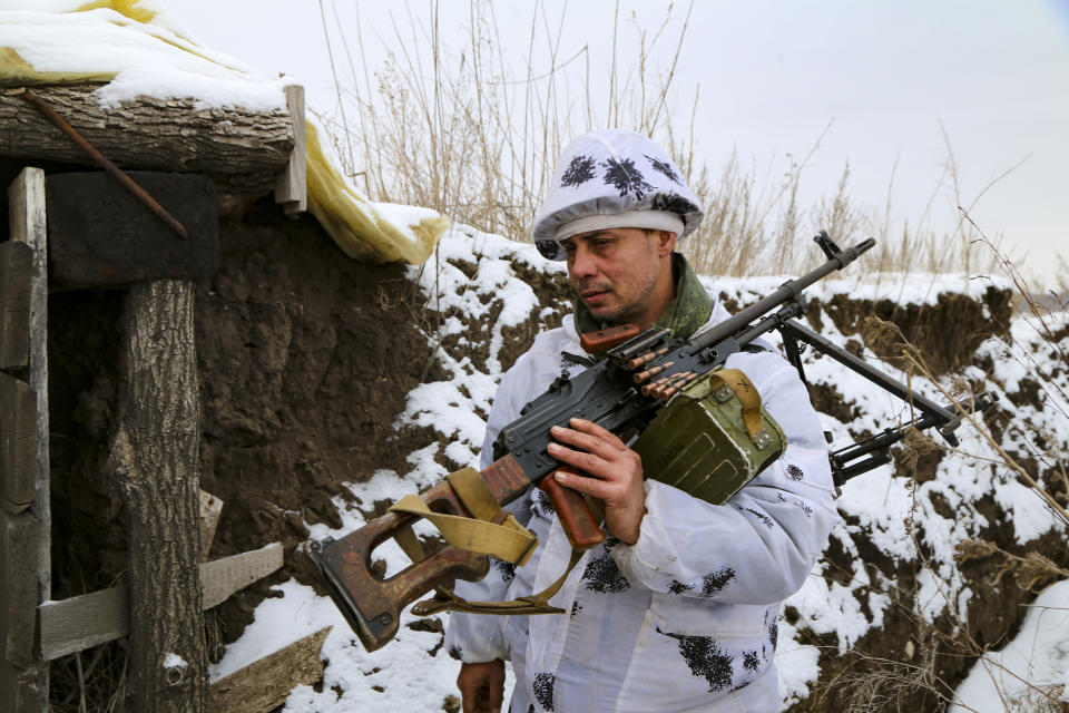 A serviceman carries his machine-gun into a shelter on the territory controlled by pro-Russian militants at frontline with Ukrainian government forces in Slavyanoserbsk, Luhansk region, eastern Ukraine, Tuesday, Jan. 25, 2022. Ukraine's leaders sought to reassure the nation that a feared invasion from neighboring Russia was not imminent, even as they acknowledged the threat is real and prepared to accept a shipment of American military equipment Tuesday to shore up their defenses. (AP Photo/Alexei Alexandrov)