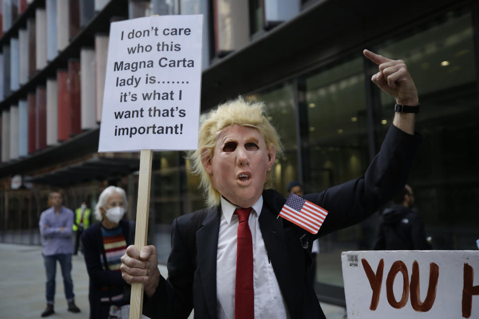 A supporters of WikiLeaks founder Julian Assange wearing a mask portraying U.S. President Donald Trump takes part in a protest outside the Central Criminal Court, the Old Bailey, in London, Monday, Sept. 14, 2020. The London court hearing on WikiLeaks founder Julian Assange's extradition from Britain to the United States resumed Monday after a COVID-19 test on one of the participating lawyers came back negative, WikiLeaks said Friday. (AP Photo/Matt Dunham)