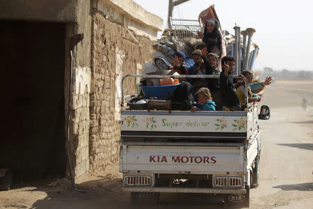 Internally displaced refugees that fled violence ride a pick-up truck in al-Kherbeh village, northern Aleppo province, Syria October 24, 2016. REUTERS/Khalil Ashawi