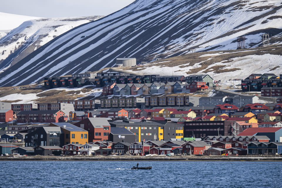 Rows of colorful houses against ice-capped mountains