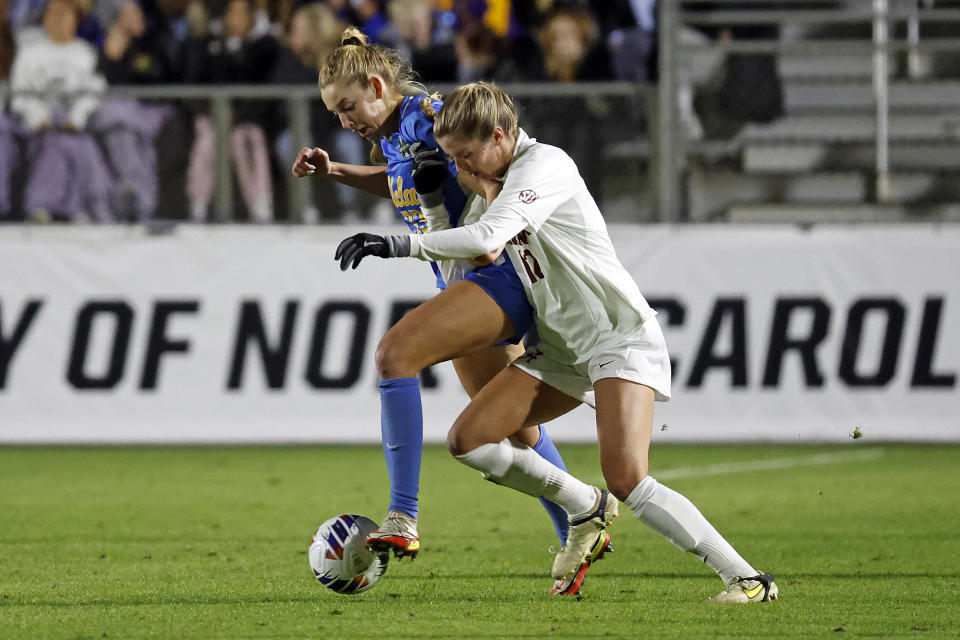 UCLA's Ally Cook, left, and Alabama's Riley Tanner, right, vie for control of the ball during the first half of an NCAA women's soccer tournament semifinal in Cary, N.C., Friday, Dec. 2, 2022. (AP Photo/Karl B DeBlaker)