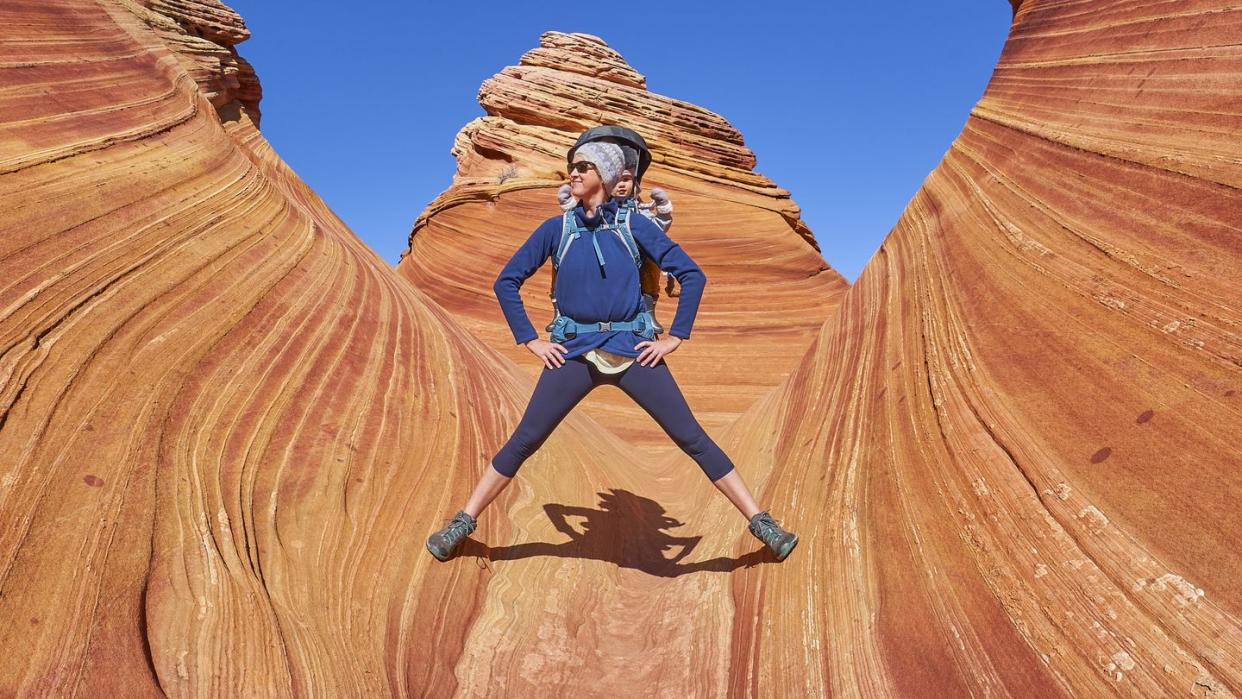 mother and toddler daughter exploring the famous wave of coyote buttes north in the paria canyon vermilion cliffs wilderness of the colorado plateau in southern utah and northern arizona usa