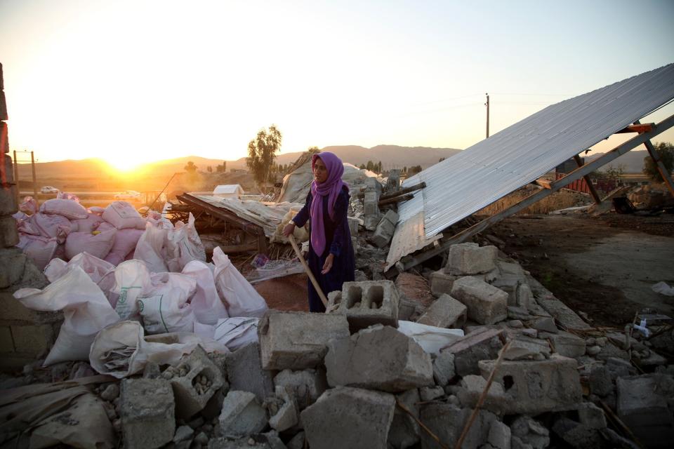 A woman struggles through the debris of a building in Kalaleh, Iran, on Tuesday,&nbsp;after a&nbsp;7.3-magnitude earthquake Sunday. (Photo: Fatemeh Bahrami/Anadolu Agency via Getty Images)