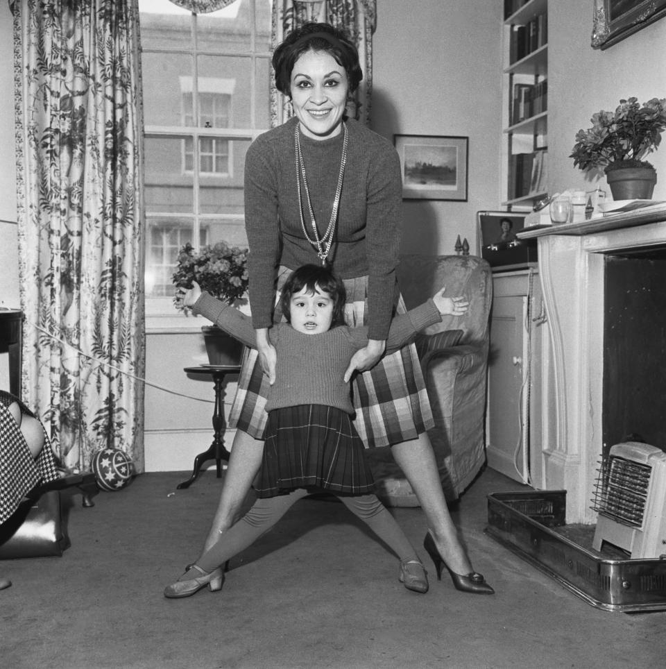 American actress and singer Chita Rivera, wearing a turtleneck sweater and playing with her daughter, Lisa Mordente, in London, England, 6th February 1962. Rivera is in London to attend the Evening Standard Theatre Awards.