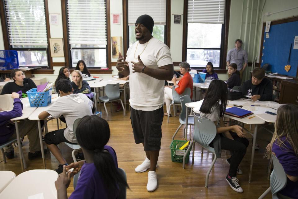 In this image provided by the Des Moines Public Schools, community activist and rap artist Will Keeps works with students at Harding Middle School on Sept. 27, 2017, in Des Moines, Iowa. Students watched his latest music video, 'Droppin' and analyzed his lyrics as part of their literacy class. Keeps is hospitalized in serious condition after surgery following just the sort of violence he's devoted his life to stop -- a shooting that killed two teenagers at the Starts Right Here educational program he founded in Des Moines. Keeps was hurt Monday, Jan. 23, 2023, when he tried to intervene. (Jon Lemons/Des Moines Public Schools via AP)