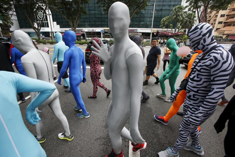 Participants wearing Zentai costumes, or skin-tight bodysuits from head to toe, take part in a march down the shopping district of Orchard Road during Zentai Art Festival in Singapore May 23, 2015. Close to 50 participants strutted down the busy shopping district during the Zentai art festival which is jointly organized by the Japanese embassy. The festival includes performances and discussions on Zentai from May 22 to from June 5. REUTERS/Edgar Su