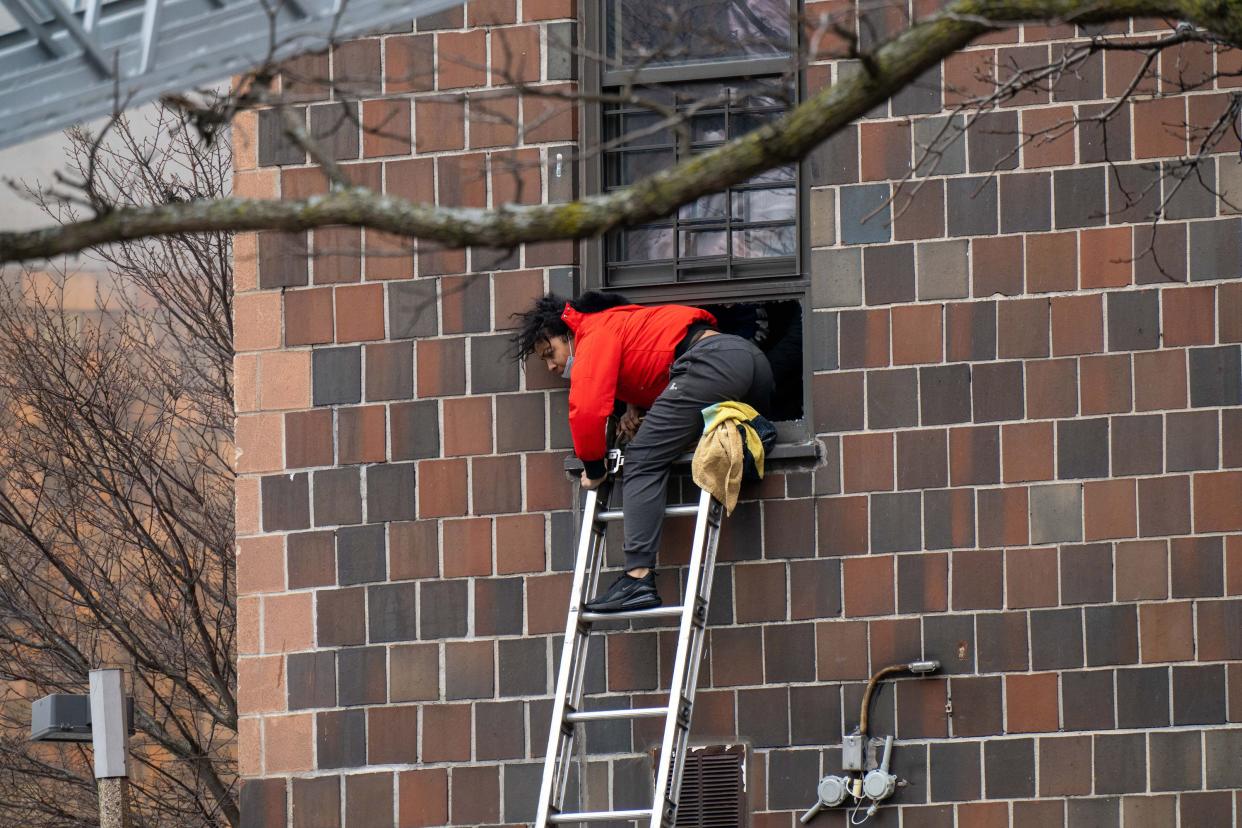 A resident of a Bronx, New York, high-rise climbs out of their window during a fire Sunday. New York City firefighter Matt Zimpfer, 45, a Hellertown native and Saucon Valley High School graduate, was among the first responders helping rescue people.