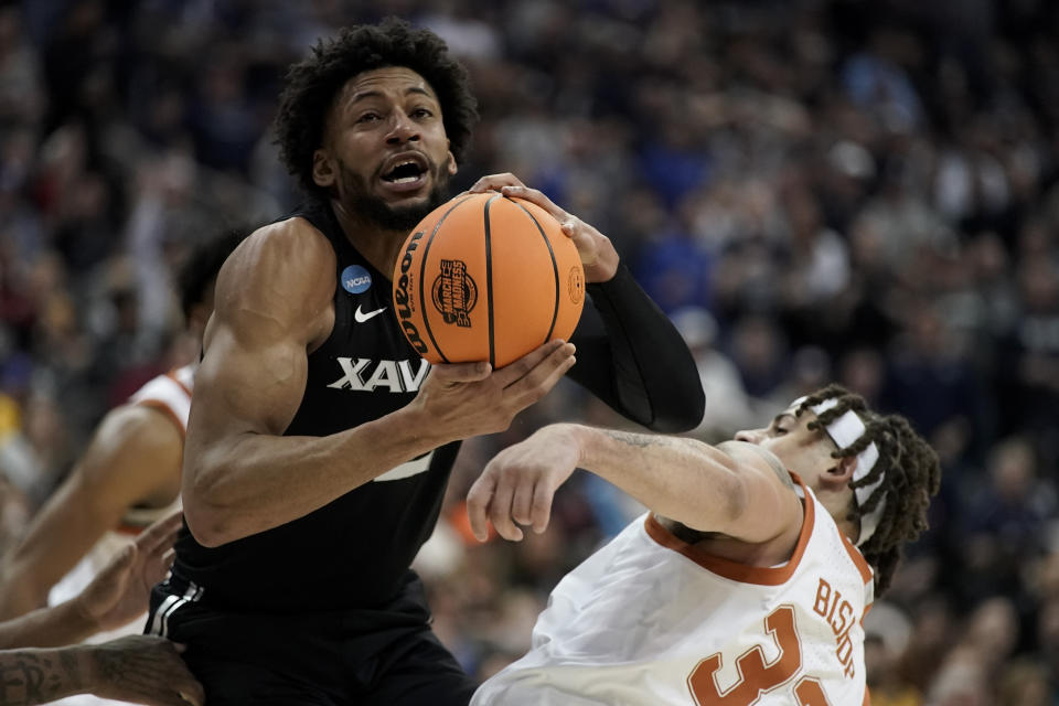 Xavier forward Jerome Hunter vies for the ball with Texas forward Christian Bishop in the first half of a Sweet 16 college basketball game in the Midwest Regional of the NCAA Tournament Friday, March 24, 2023, in Kansas City, Mo. (AP Photo/Charlie Riedel)