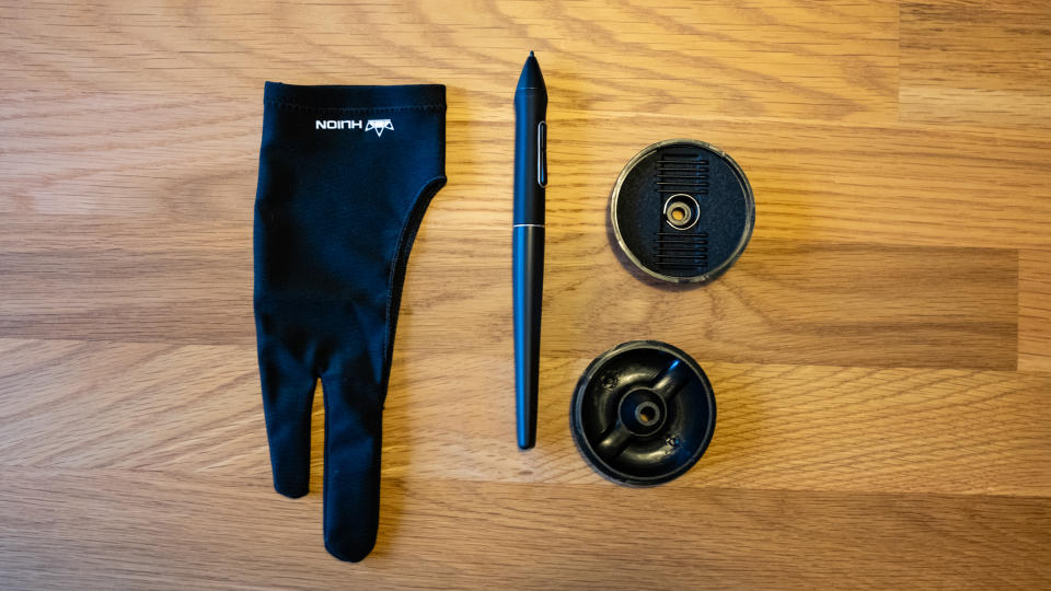 Selection of accessories for a Huion Kamvas 13 on a wooden surface