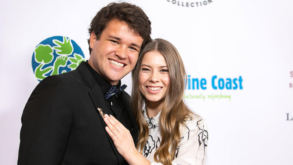 Bindi Irwin puts her hand on Chandler Powell's chest as the couple step out together on the red carpet