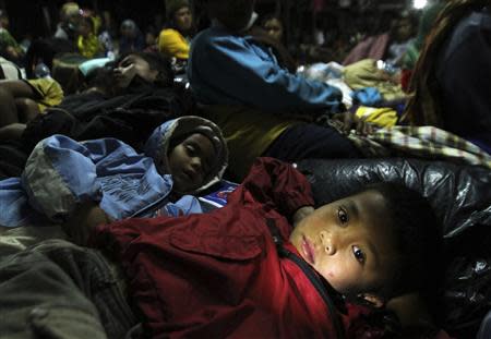 A child refugee lies down at temporary shelter as a safety precaution after Sinabung volcano erupted at Tiganderket village in Karo district, Indonesia's north Sumatra province, November 3, 2013. REUTERS/Roni Bintang