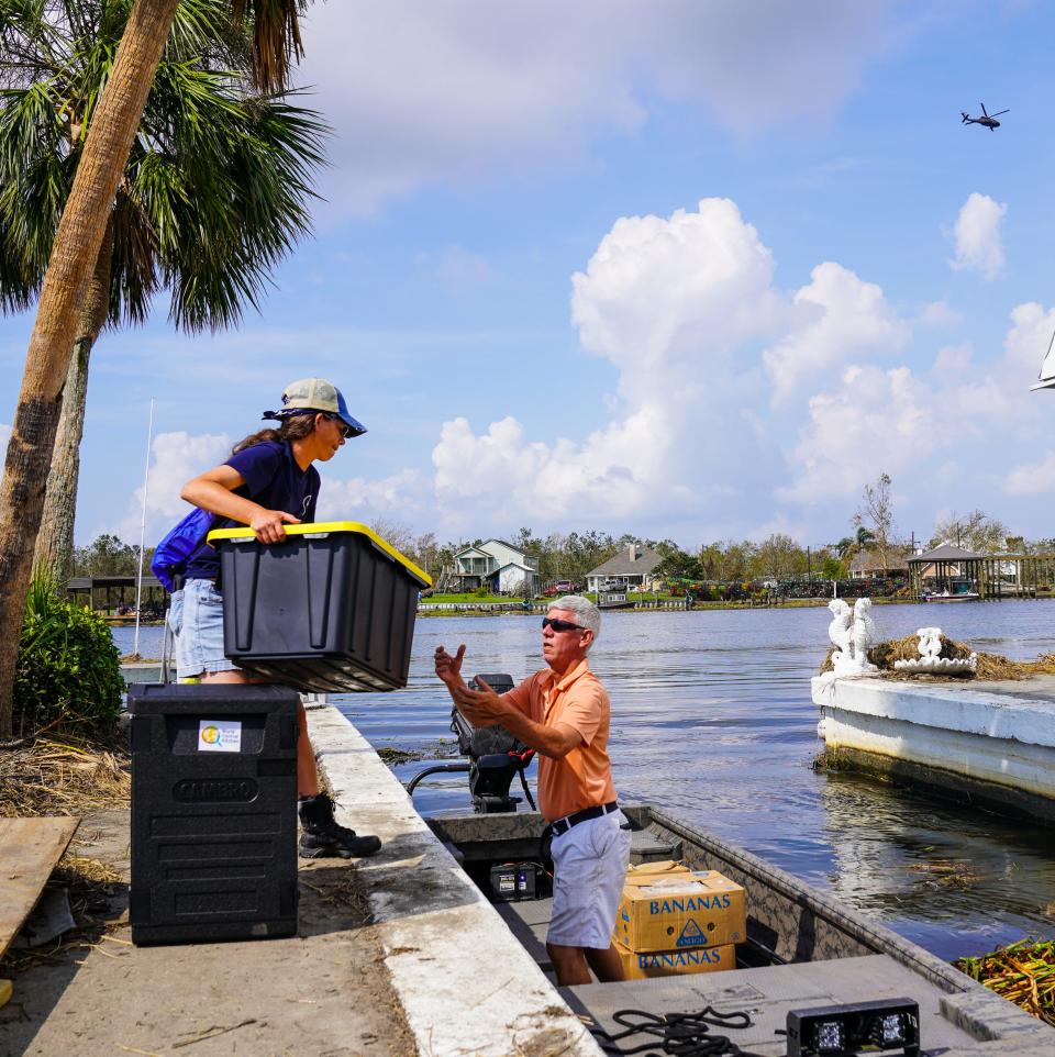 Colleen Udell and Chris Doran of Cajun Navy Relief load food donated by World Central Kitchen to deliver to the island of Barataria, La., cut off after the passage of Hurricane Ida.