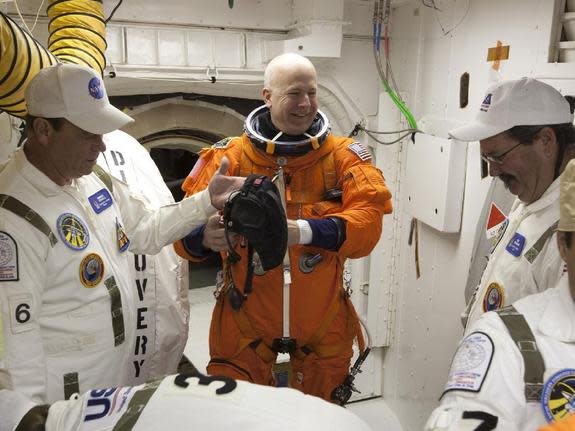 At NASA's Kennedy Space Center Launch Pad 39A, STS-131 Commander Alan Poindexter, in the orange suit, prepares to enter space shuttle Discovery from the pad's White Room during the practice countdown known as the Terminal Countdown Demonstratio
